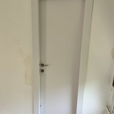 דלת לבנה עם ידית מתכת ומפתח