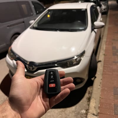 מפתח רכב מול מכונית חונה ברחוב