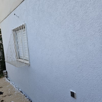 קיר צבוע מחדש עם שאריות צבע על הרצפה