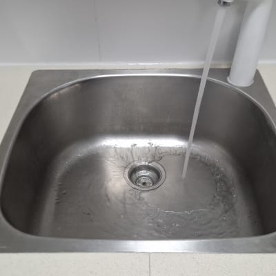 כיור נירוסטה עם מים זורמים מהברז