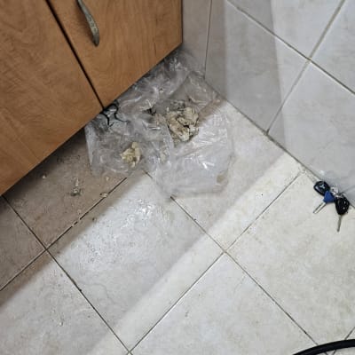 רצפה רטובה עם שקית ניילון וכלי עבודה של אינסטלטור