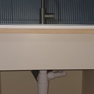 כיור עם ברז וצנרת מתחת לכיור