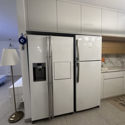 מקררים לבנים במטבח מודרני עם ארונות עליונים