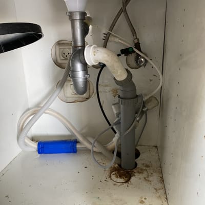 צנרת מתחת לכיור עם חיבורים ונזילה