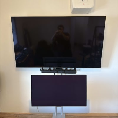 מסך טלוויזיה ומסך מחשב מותקנים על קיר