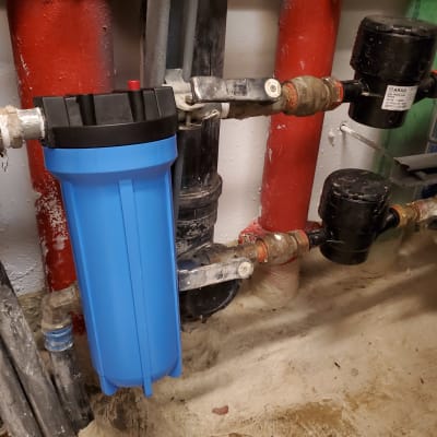 מסנן מים כחול וצינורות מתכת מחוברים