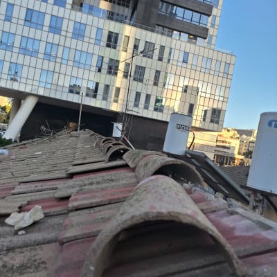 גג רעפים עם אנטנה ומיכלי מים