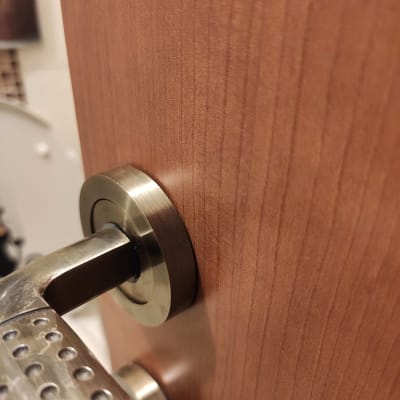 ידית דלת מתכתית על דלת עץ