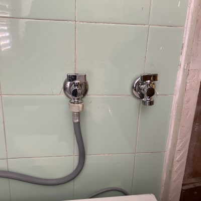 ברזים כרומיים על קיר עם צינור אפור