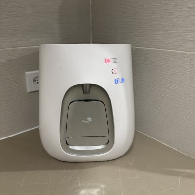 מתקן מים עם כפתורים מוארים על משטח שיש