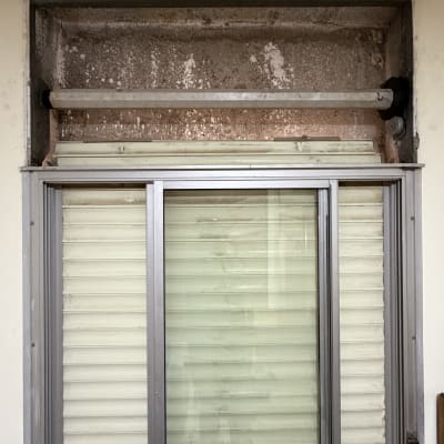 חלון עם תריסים ישנים ומסגרת מתכת