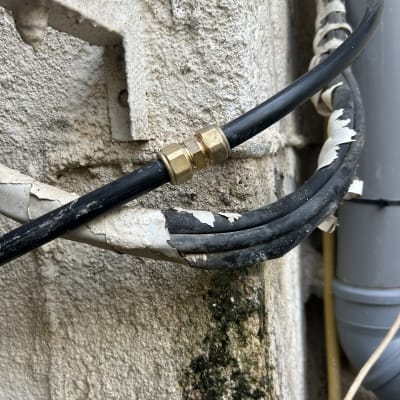 חיבור צינור עם מחבר מתכת על קיר חיצוני