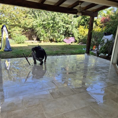 אדם מנקה רצפת מרפסת עם מגב