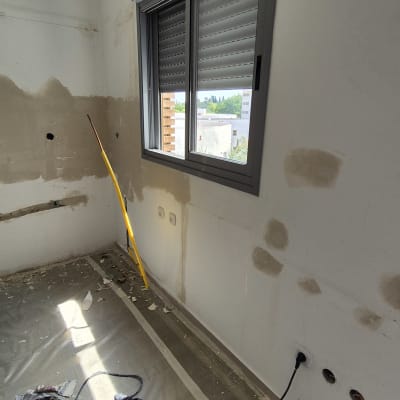 חדר בשיפוץ עם קירות מטויחים וכלי עבודה