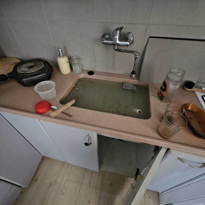 כיור מטבח עם מים עומדים וברז נירוסטה