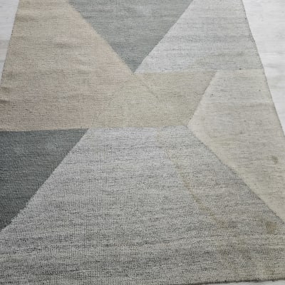 שטיח גיאומטרי בצבעים ניטרליים על רצפה בהירה