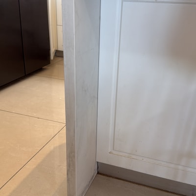 משטח שיש במטבח עם ארון לבן ורצפת אריחים