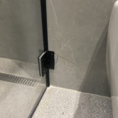 זכוכית ומסגרת מתכת במקלחת מודרנית