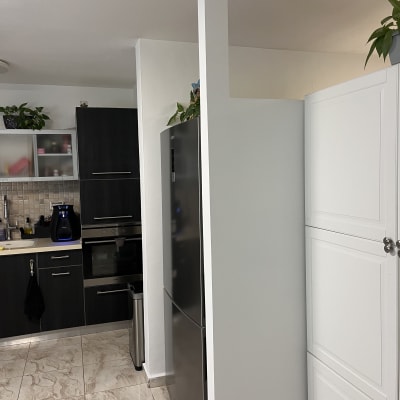 מטבח מודרני עם ארונות כהים ומקרר כסוף