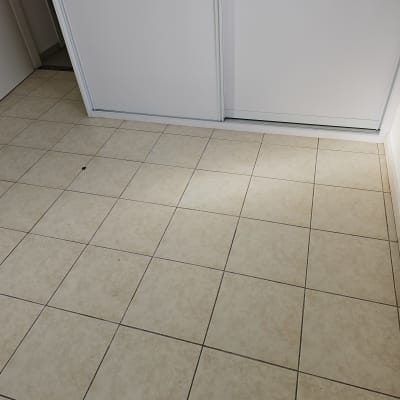 רצפת אריחים לבנים ודלת הזזה לבנה