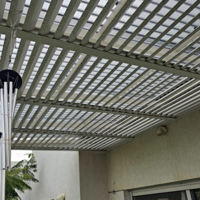 פרגולה מתכתית עם רשת מעל גינה