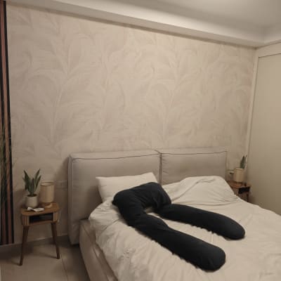 חדר שינה עם טפט על הקיר ומיטה מסודרת