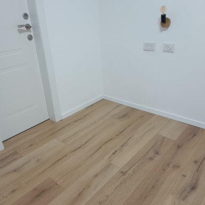 רצפת פרקט בחדר עם דלת ושקעי חשמל