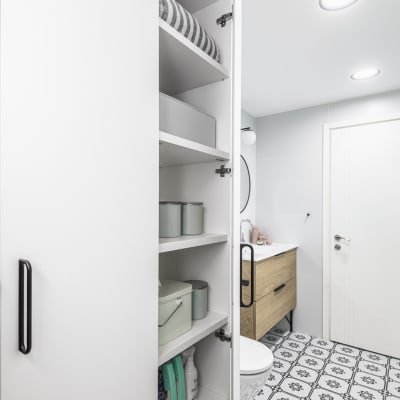 ארון פתוח עם מדפים, קופסאות ואביזרי ניקוי