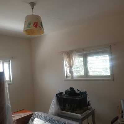 חדר עם רהיטים מכוסים בניילון לקראת צביעה