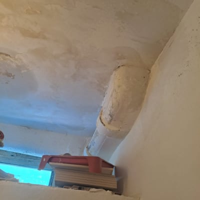 תקרת גבס עם צינור ותיקונים נראים