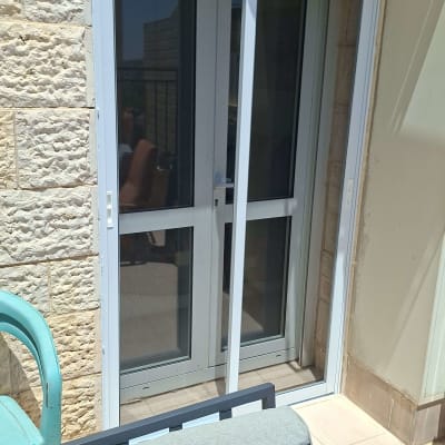 דלת הזזה מאלומיניום במרפסת עם כיסא