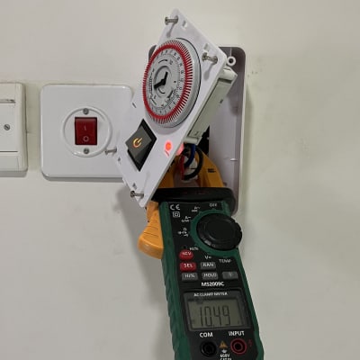 מד מתח מחובר לשעון טיימר חשמלי בקיר