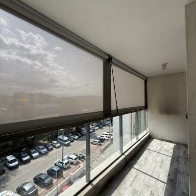 מרפסת עם סוכך גלילה ושמשות זכוכית