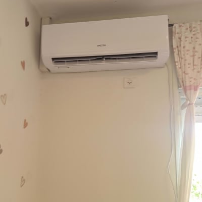 מזגן קיר לבן מותקן על קיר חדר