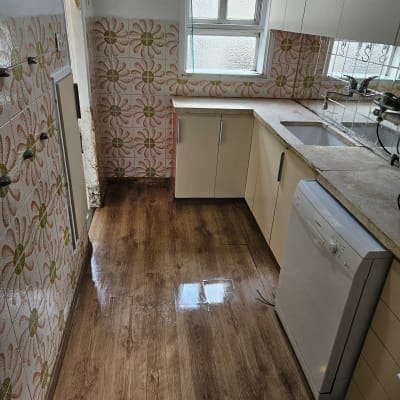 מטבח נקי עם רצפה מבריקה וארונות מסודרים