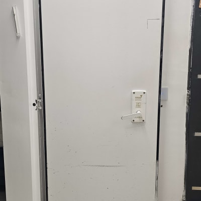 דלת לבנה עם ידית ומסגרת שחורה