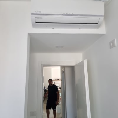 מזגן מותקן על קיר לבן בחדר פנימי