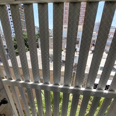 רשת מתכת מותקנת על גדר למניעת כניסת יונים