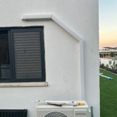 יחידת מזגן חיצונית מותקנת על קיר לבן