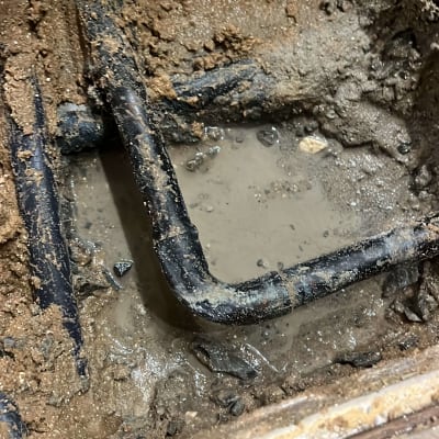 צינור מתכת מכופף בתוך בוץ רטוב