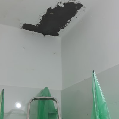 סולם מתכת ליד תקרה עם תיקון טיח שחור