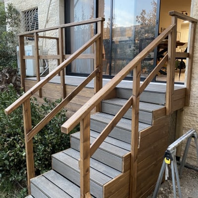 מדרגות עץ עם מעקה ליד בית