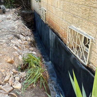 חיפוי איטום שחור על קיר חיצוני של מבנה