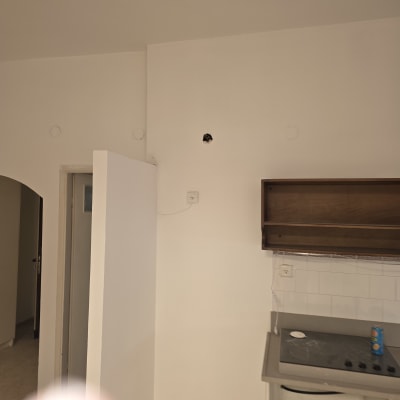 קיר צבוע עם חור קטן ליד מטבח