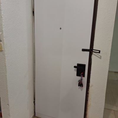 דלת לבנה עם ידית שחורה ומפתח תלוי