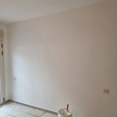 קיר צבוע עם דלי צבע ומברשת על הרצפה