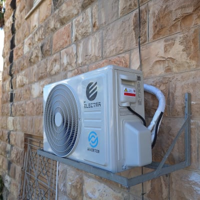 יחידת מיזוג אוויר חיצונית מותקנת על קיר אבן