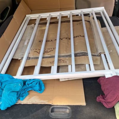 מסגרת מתכת בתוך תא מטען של רכב עם קרטונים