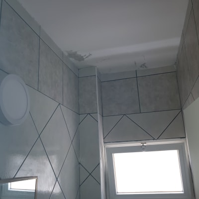 תקרה עם קילופי צבע ליד חלון קטן