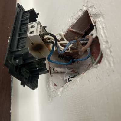 שקע חשמלי פתוח עם חוטים חשופים בקיר